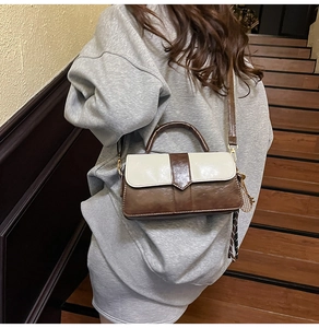 Détail du sac bandoulière bicolore avec pendentif raquette de tennis et sangle