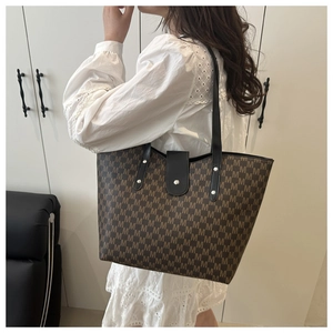 Detail view of large tote bag with brown M-pattern print and snap button closure