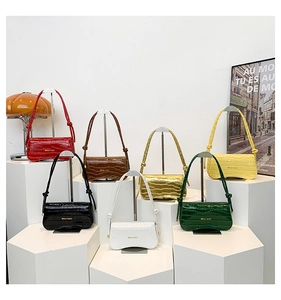 Macro shot of 7-piece crocodile embossed bags set in various colors on display