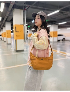 Détail d'un sac bandoulière en nylon jaune moutarde avec bandoulière réglable