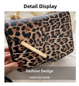 Detail showing leopard print texture, golden bar buckle, and metallic chain strap