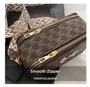 Close-up of dual smooth zippers and wide jacquard strap on vintage crossbody bag