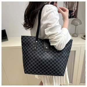 Detailed view of large capacity tote bag with M letter print and metal rivet reinforcement