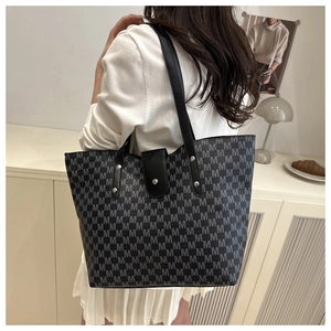 Large grey tote bag with M-letter print and black straps shown in a lifestyle interior