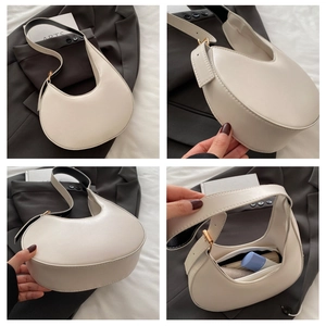 Detailed views of cream crescent handbag showing interior space and wide strap