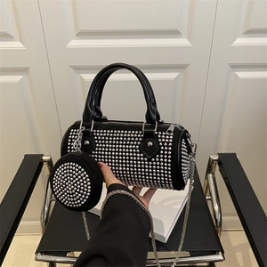 Fashionable black cylinder handbag with silver studs and a chain strap set