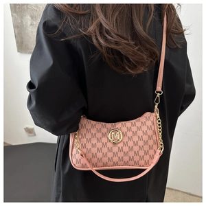 Detailed view of pink jacquard hobo bag with gold metal logo and adjustable strap