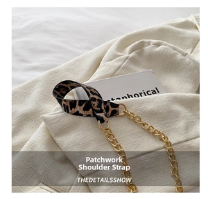 Close-up of leopard print fabric and gold metal chain strap with ring buckle