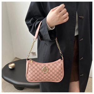 Close-up of pink monogram crossbody bag with golden metal chain and M-shaped logo