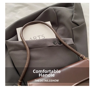 Detail of premium brown leather handle with meticulous stitching and gold metal hardware