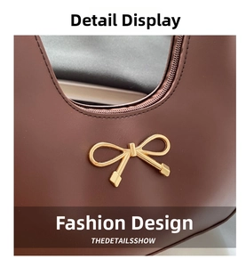 Detail der dunkelbraunen Leder-Baguette-Tasche mit goldener Schleife und Reißverschluss