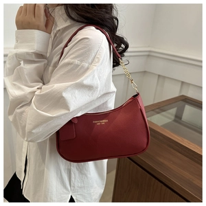 Seitenansicht der roten Hobo-Tasche aus strukturiertem Leder mit goldener Kette am Model