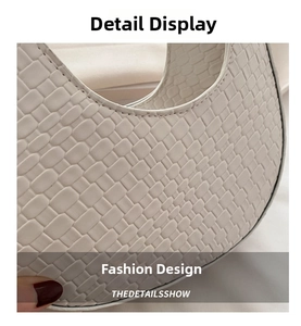 Detail shot of beige crescent bag featuring premium woven texture and refined hand-stitching
