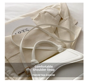 Detail showing the unique knot handle design and gold buckle of this white shoulder bag