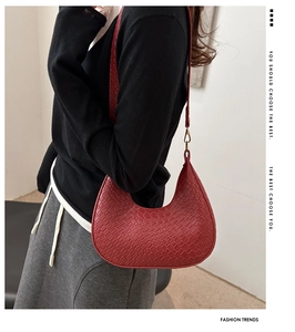 Detail shot of the red crescent hobo bag featuring premium woven texture and gold metal buckle