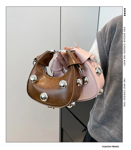 Detailed view of fashionable crescent handbags with metallic studs in brown and pink