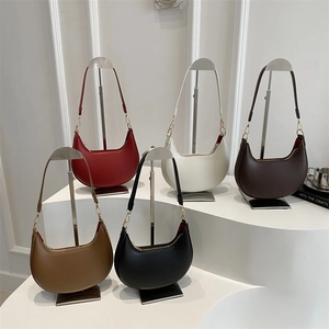 Minimalistische Halbmond-Schultertaschen in fünf Farben auf professionellen Metallständern