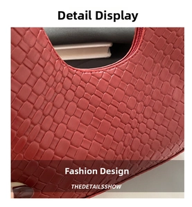 Close-up of deep red woven texture on a crescent bag with top zipper and luxury finish