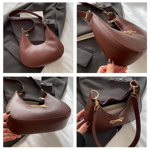 Detailansicht der rotbraunen Hobo-Tasche mit goldener Schleife und Reißverschluss