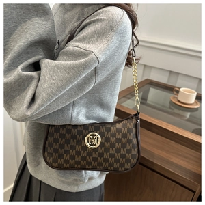 Close-up of brown monogram hobo bag with gold M logo and leather chain strap detail