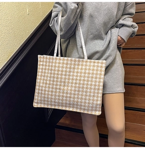 Detailed view of houndstooth tote bag featuring premium fabric and sturdy shoulder straps