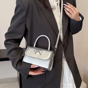 Chic silver metallic mini handbag with bow decor, crossbody style for women