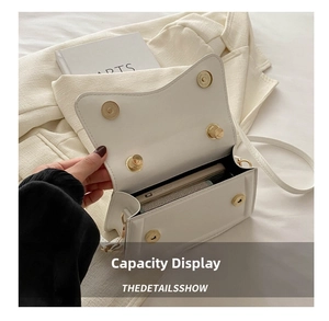Internal view of a white leather crossbody bag showing spacious capacity for smartphones