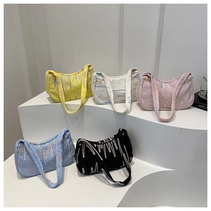 Close-up of hobo bags with embossed monogram texture and colorful hanging embroidery details