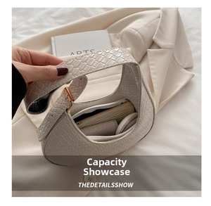 Detailed view of the large interior capacity for an ivory woven crescent shoulder bag