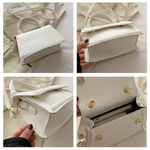 Detail view of white square crossbody bag showing metal buckle, strap, and interior capacity