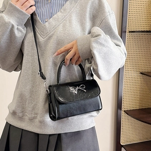 Minimalist black square crossbody bag with silver metal bow and top handle for women