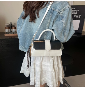 Vue en bandoulière d'un petit sac carré contrasté noir et blanc sur un mannequin
