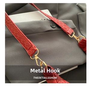 Detail of red woven leather strap with premium gold metal hook on a shoulder bag