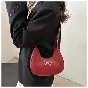 Detailansicht der dunkelroten Leder-Schultertasche mit goldener Metallschleife