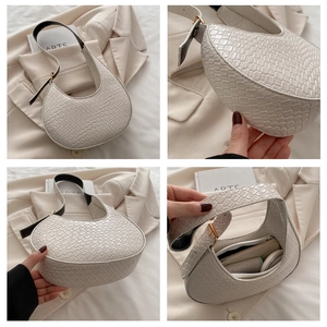 Detail view of white woven crescent bag showing interior space and braided texture