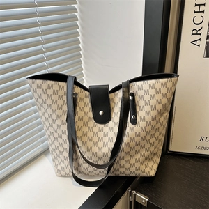 Large capacity tote bag featuring grey M-pattern monogram and black leather straps
