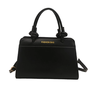 Chic black matte trapezoid handbag with unique knotted handle and gold metal lettering