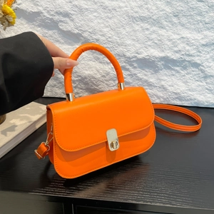 Chic orange faux leather handbag with gold lock and top handle for versatile shoulder wear