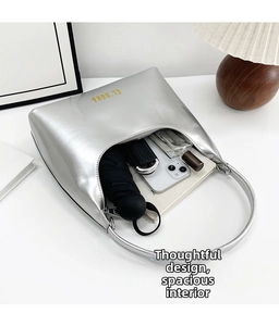 Spacious interior of the silver patent baguette bag showing phone and umbrella storage