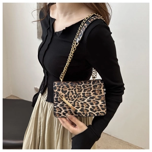 Detail of leopard print crossbody bag with golden chain strap and metallic buckle decoration