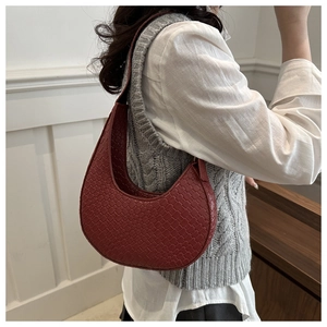 Detail of burgundy woven hobo bag showing intricate texture and crescent shape on shoulder