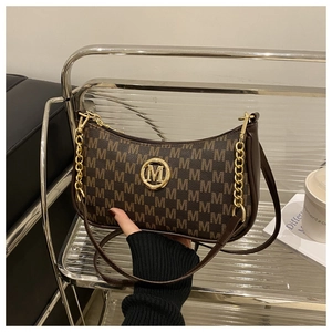 Close-up of brown monogram hobo bag with gold M-logo and metallic chain handle