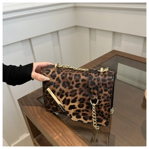 Détail du sac léopard avec bandoulière en chaîne dorée et finitions métalliques chic