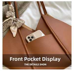 Close-up of brown leather tote bag front pocket with a decorative patterned silk scarf