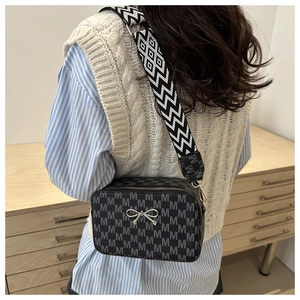 Back view of a black crossbody bag with grey M pattern and wide geometric shoulder strap