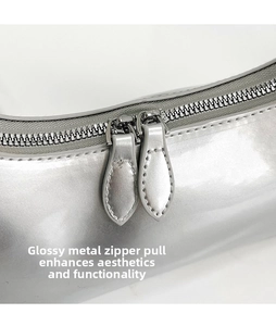 Macro shot of silver patent leather bag featuring teardrop double metal zipper heads