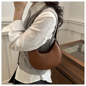 Detailed view of brown woven crescent bag texture and premium faux leather finish