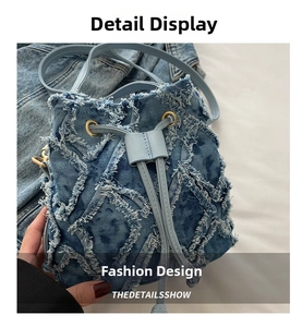 Dettaglio borsa a secchiello in denim blu con texture sfrangiata e tracolla a catena oro