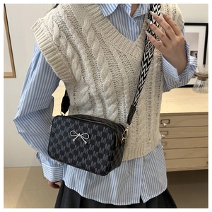 Detail of dark grey monogram crossbody bag with silver bow and geometric wide strap