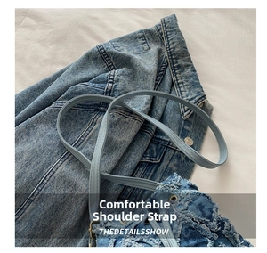 Dettaglio della comoda tracolla in denim blu chiaro e dell'anello di aggancio della borsa
